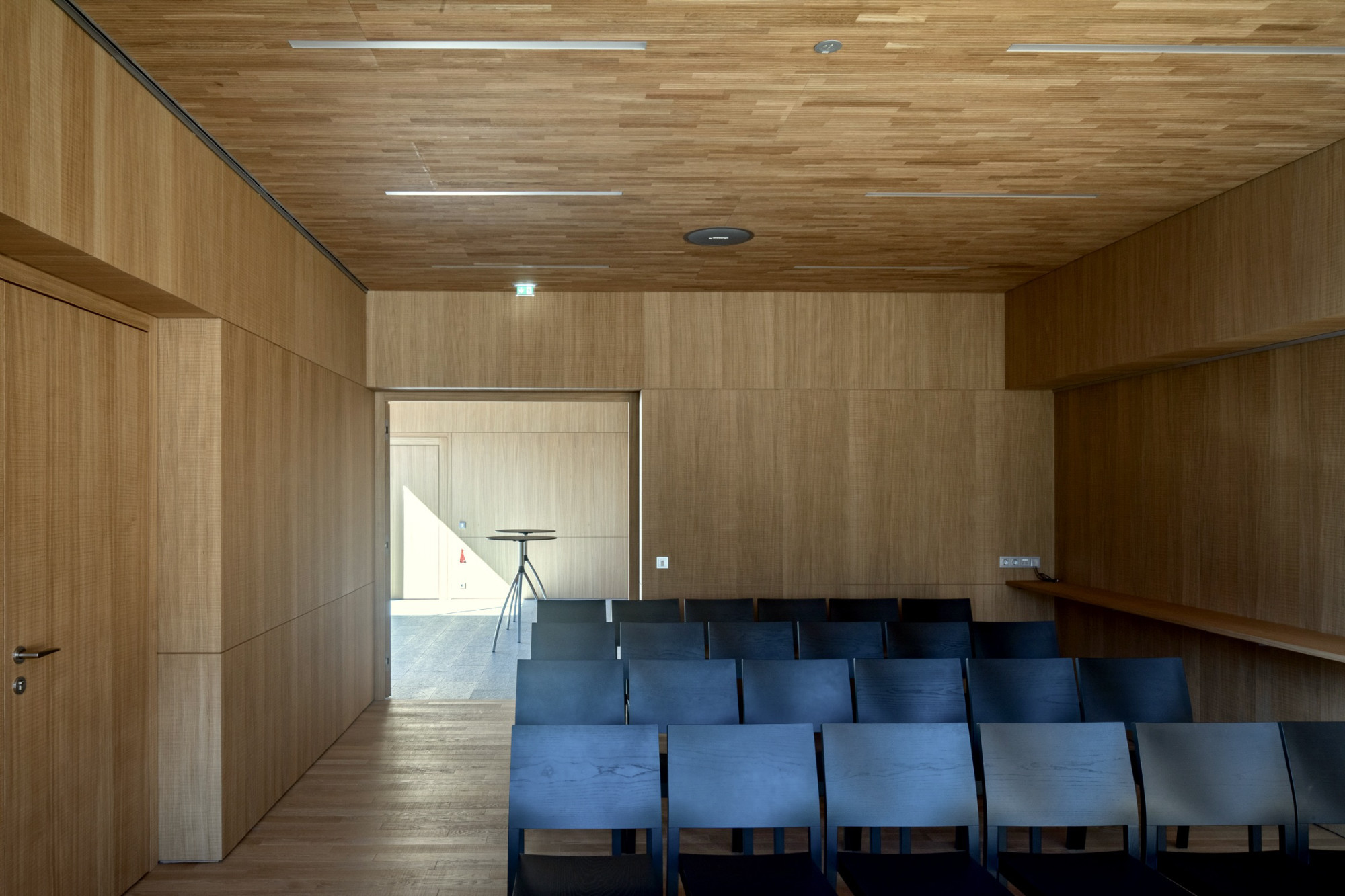 Gemeindezentrum Haiming, Sitzungssaal mit Holzverkleidung, Bestuhlung und Akustikdecke